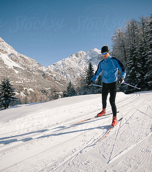 Man with orange ski boots doing Nordic skiing