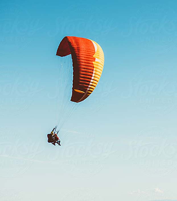 Jackson Hole tandem paragliding with orange and yellow paraglide