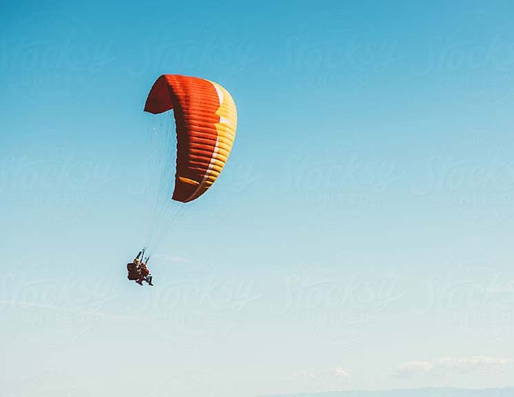 Jackson Hole Paragliding with orange and yellow paraglider