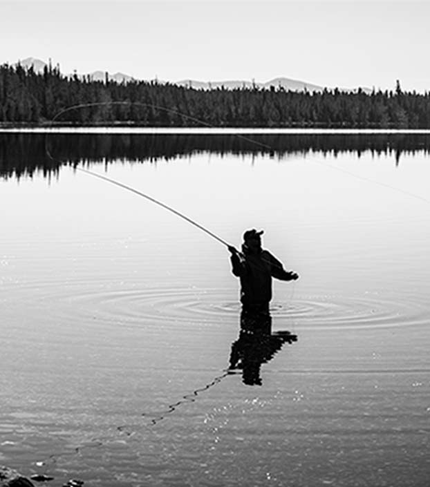 Fisherman fly fishing in black and white photo