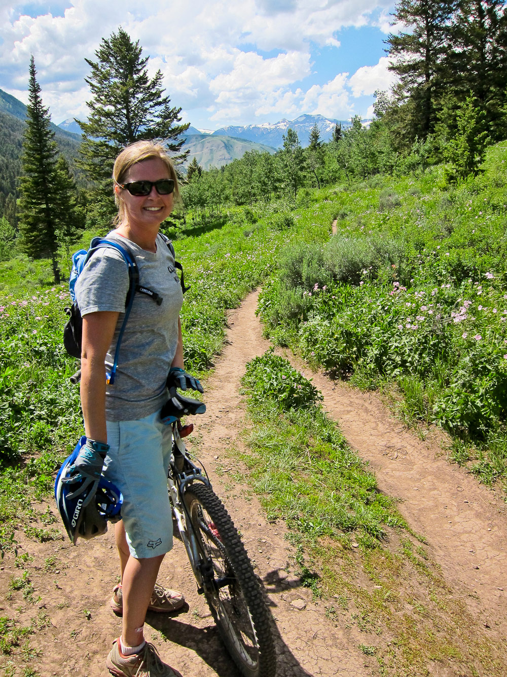 Woman standing by her mountain bike on trail near Jackson Hole