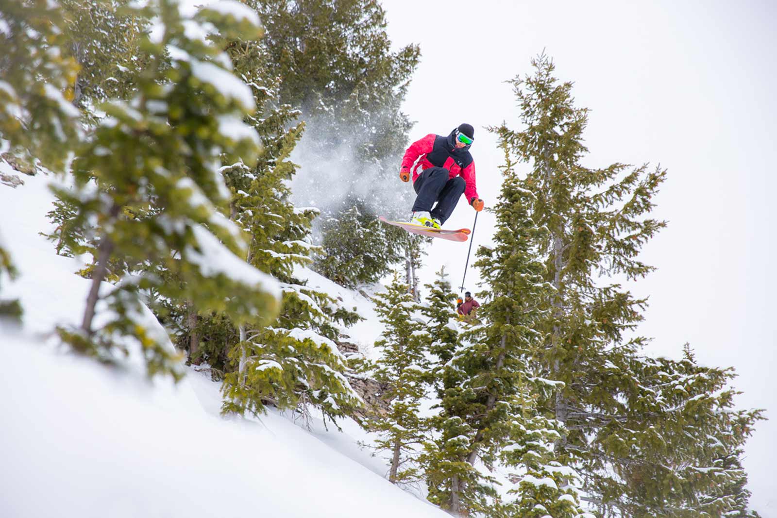 Skier in the air by trees at Grand Targhee Ski Resort Alta WY