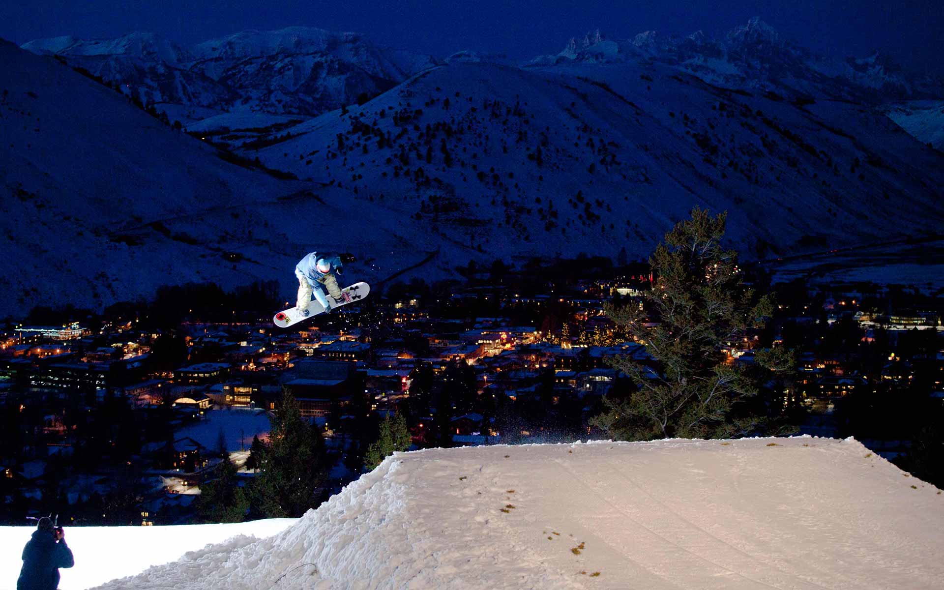 Snowboarder in air after jump at night at Snow King Mountain Jackson WY