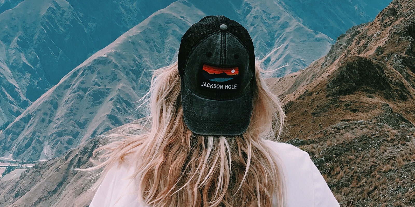 Woman with Jackson Hole baseball cap looking out over mountain range