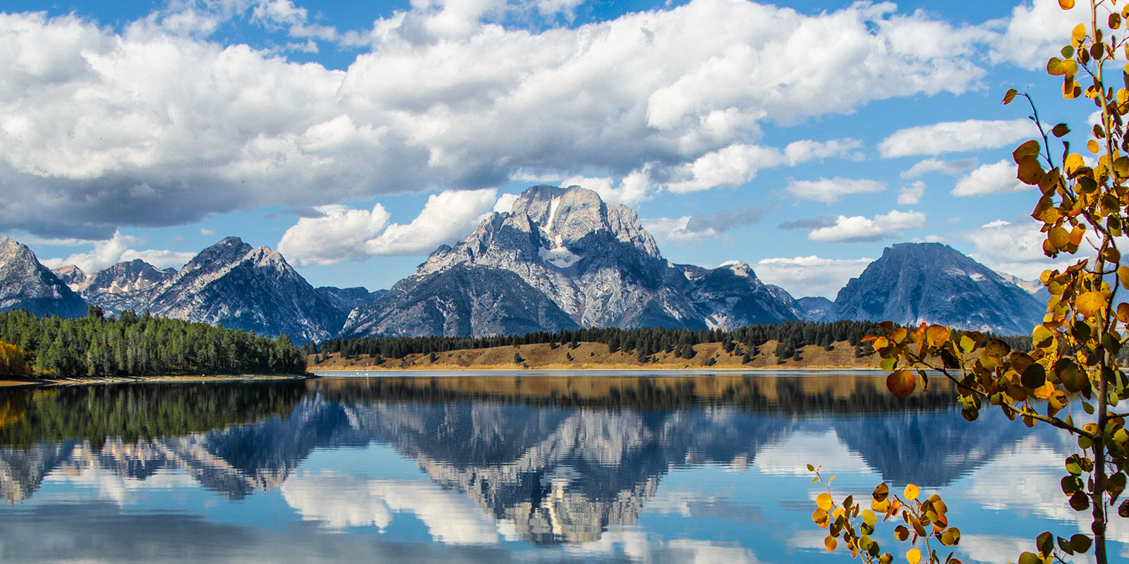 Mountain lake with reflection of Grand Tetons in fall