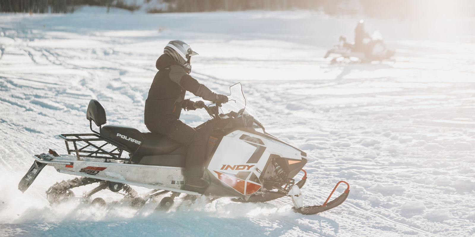 Two snowmobilers riding over the snow