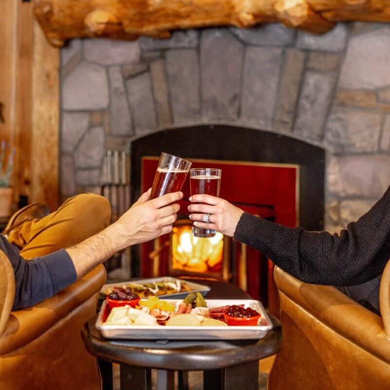 Beer and nachos at the Triple M in front of fireplace with a couple with beers